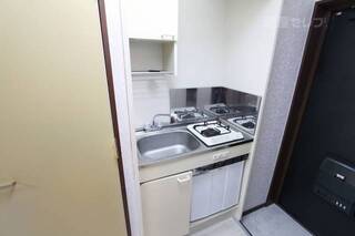 小さい冷蔵庫付きのキッチンです。106号室の写真です。