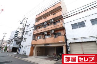 ビルの合間に際立つカラーのマンションです。