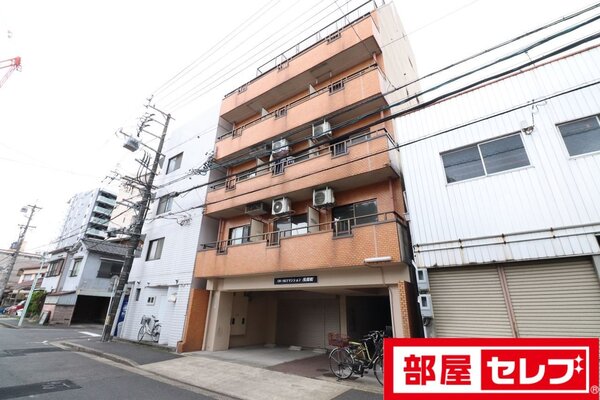 ビルの合間に際立つカラーのマンションです。
