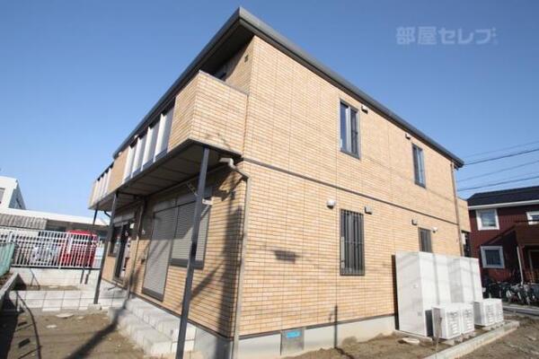 日差しが降りそそぐコーラルオレンジの外壁
